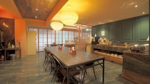 A modern kitchen with a wooden dining table, bar stools, and a large island with appliances. - February Hotel The Stay Gangseo Main Building (Busan)
