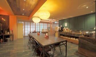Una cocina moderna con una mesa de comedor de madera, taburetes de bar y una isla grande con electrodomésticos.