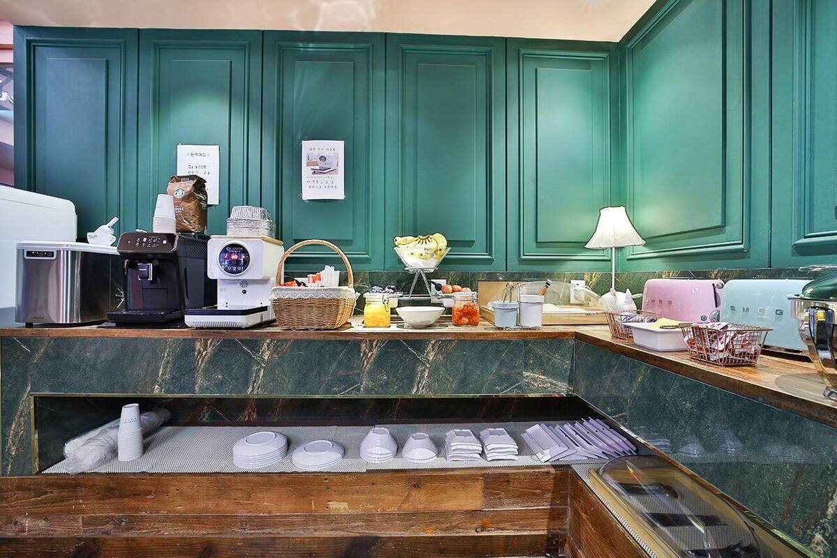 A breakfast bar with a coffee machine, toaster, and various breakfast items.