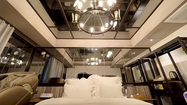 A modern hotel room with a bed, a vanity mirror, and a chandelier. - February Hotel The Stay Gangseo Main Building (Busan)
