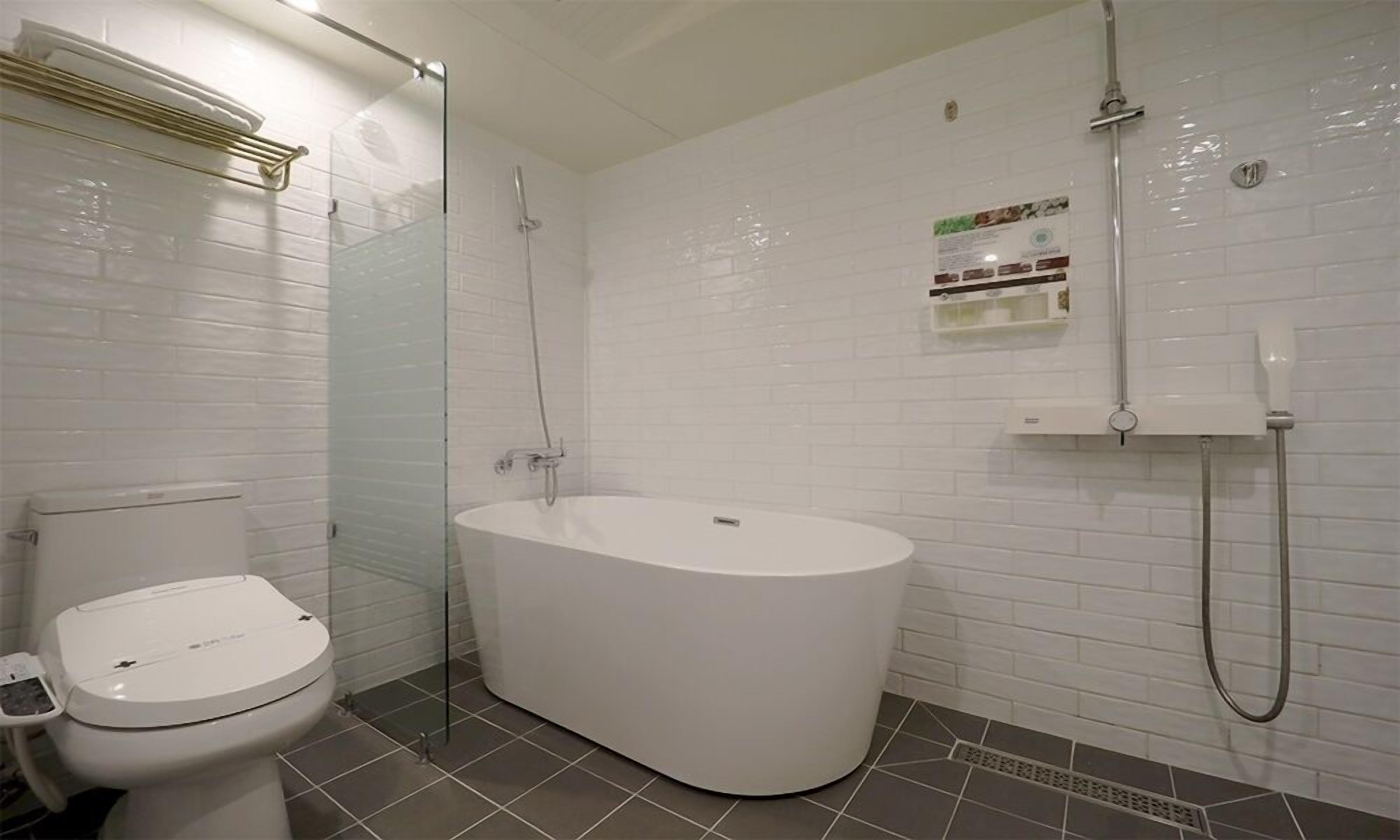 A bathroom with a toilet, a bathtub, and a shower.