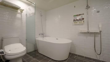 A bathroom with a toilet, a bathtub, and a shower.
