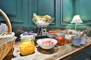 A breakfast buffet with various fruits, a fruit basket, a bowl of pastries, a jar of jam, and a lamp. - February Hotel The Stay Gangseo Main Building (Busan)
