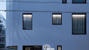 A modern building with multiple windows, a glass entrance, and a sign indicating '9h nine hours'. - 9h nine hours Ningyocho (Tokyo)