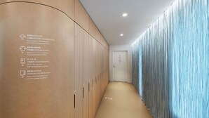 A hotel corridor with lockers on the left and a blue curtain on the right. - 9h nine hours Ningyocho (Tokyo)