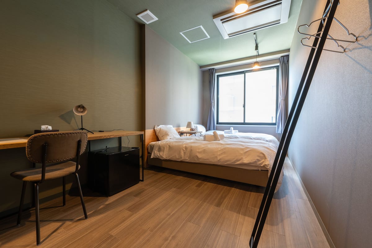A compact room with a bed, a desk, and a chair.