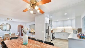 A modern kitchen with white cabinets, stainless steel appliances, and a central island.