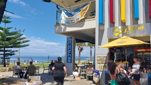 A beachfront cafe with outdoor seating, a sign for 'Munchas', and a 'Crave Coffee' stand. - Secluded Pool House getaway- 500m to patrolled Shelly Beach (Shelly Beach)