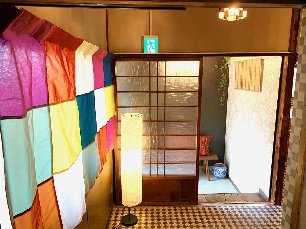 A traditional Japanese room with tatami flooring, a shoji screen door, and a hanging lantern.
