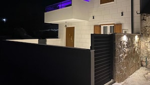 A modern two-story house with a flat roof, white exterior walls, and a stone wall on the right side. - Villa Antica (Rogoznica)