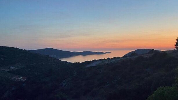 A balcony with a view of a mountainous landscape and a body of water during twilight. - Villa Antica (Rogoznica)