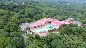 Vista aèria d'un complex turístic amb piscina, envoltat per un bosc dens.
