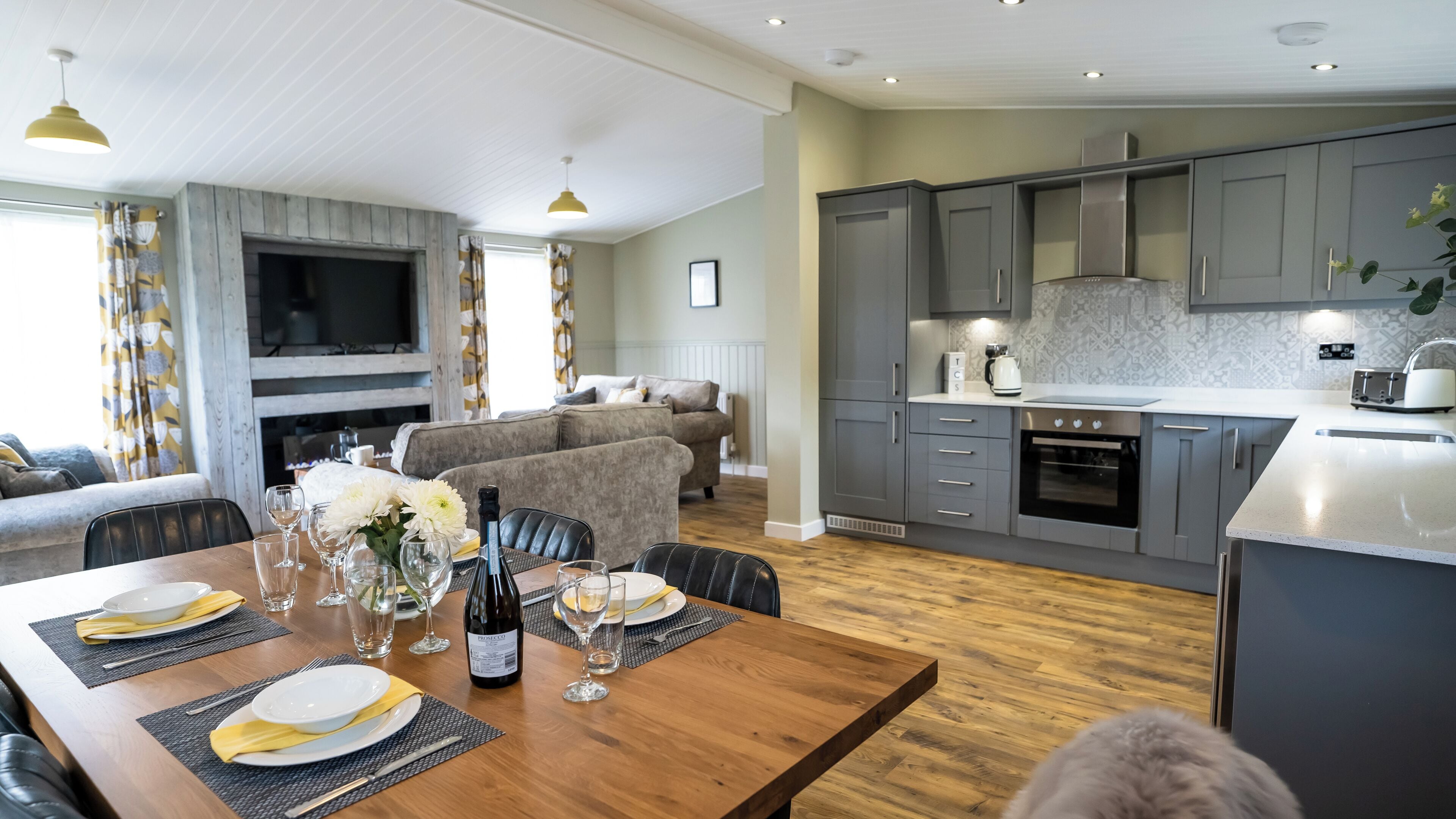 A modern kitchen with grey cabinets, a built-in oven, and a microwave.