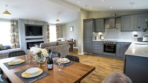 A modern kitchen with grey cabinets, a built-in oven, and a microwave. - Chestnut Meadow Country Park (Bexhill-on-Sea)