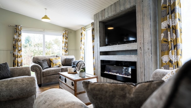 Una sala de estar con sofá, sillones, una mesa de centro y chimenea.