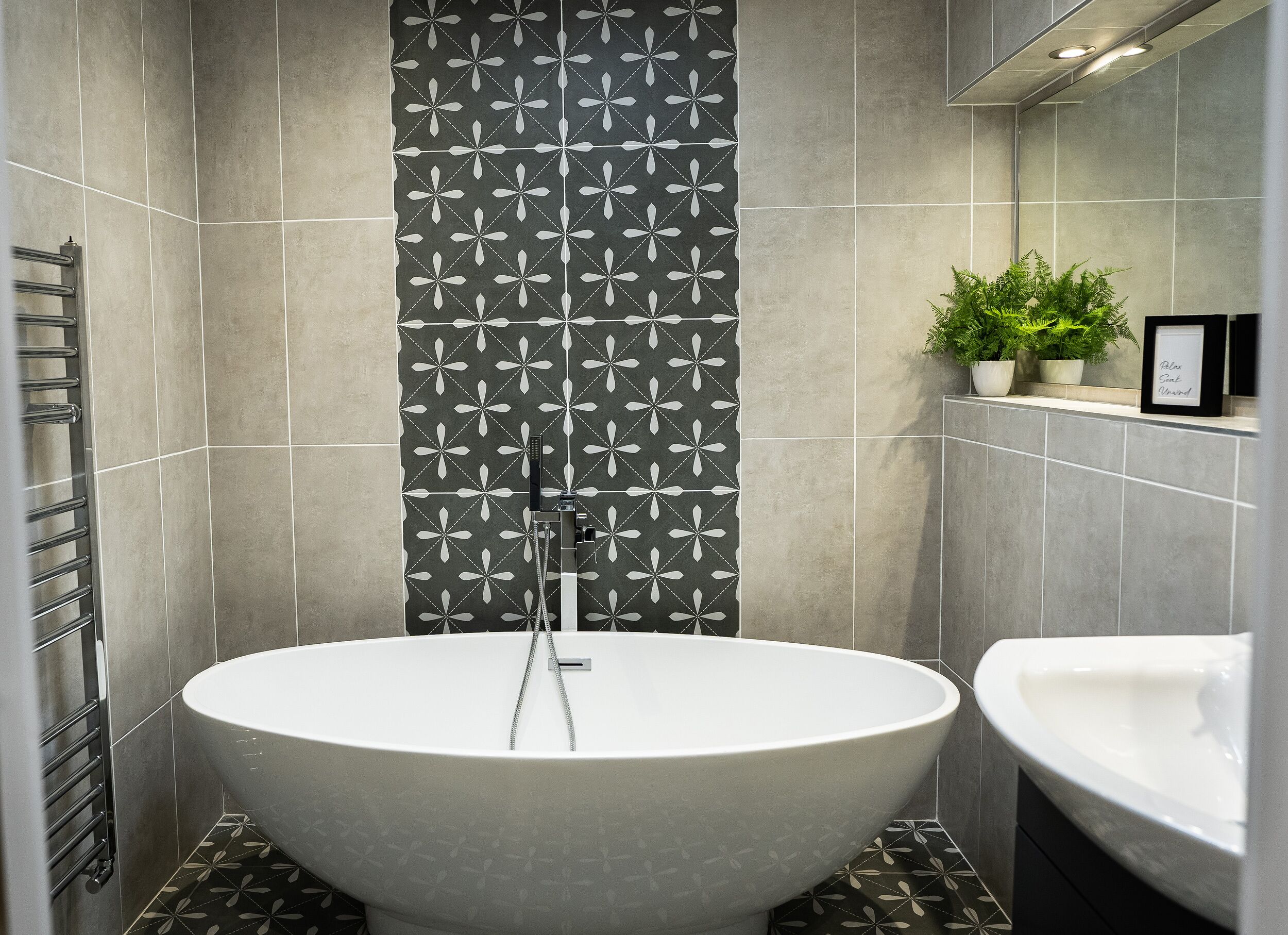 Un baño moderno con una bañera independiente, ducha empotrada y lavamanos.