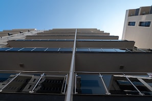 A modern building with multiple floors, large windows, and a central vertical structure. - Apartamente Astoria (Navodari)