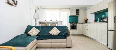 A modern living room with a sofa and a dining area.