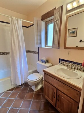 Une salle de bain équipée d’une douche, de toilettes, d’un lavabo et d’un meuble-lavabo.