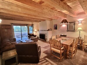Un salon chaleureux avec une cheminée, une table à manger en bois et des sièges confortables.
