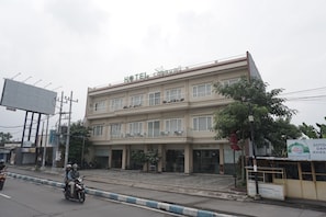 A hotel with a flat facade, multiple balconies, and a signboard advertising 'HOTEL SANTANA'.
