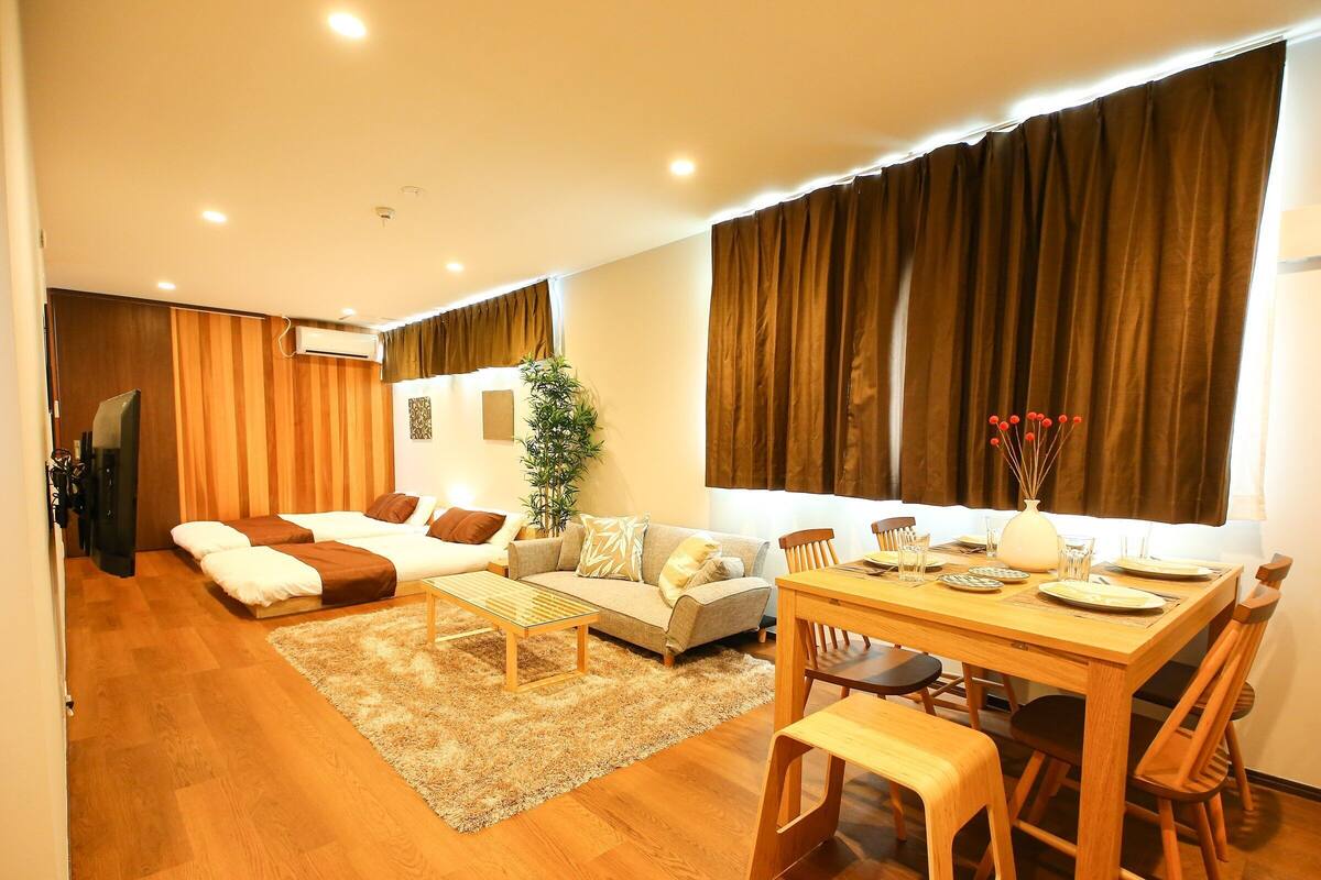 A modern living room with a sofa, a dining table, and a TV.