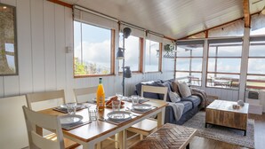 A dining area with a wooden table set for four, a sofa, and a small coffee table. - Top Of The World Lodge (Aberdovey)