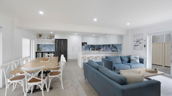 Una cocina moderna con armarios blancos, un refrigerador negro y un salpicadero azul.