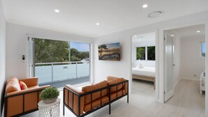 Una habitación moderna con balcón, una cama y un cuadro.