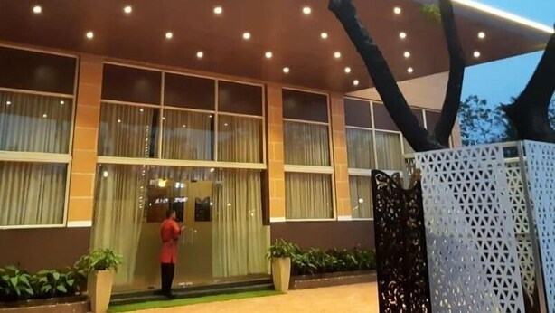 A modern building with a flat roof, large windows, and a well-lit entrance. - The Grand Neelam Hotel (Raipur)