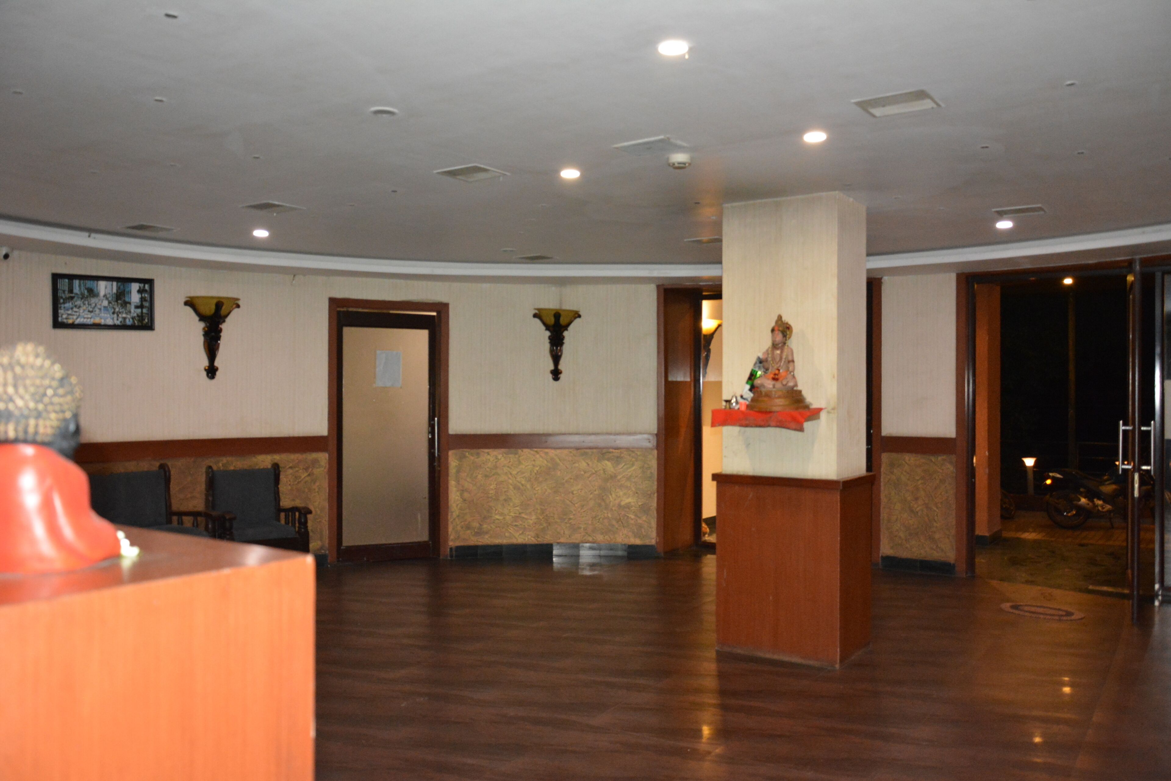 A lobby with a reception desk, seating area, and a statue.