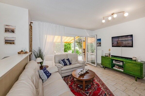 Una sala de estar moderna con un sofá, una mesa de centro y un televisor en la pared.