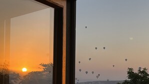 Une vue sur un paysage urbain au coucher du soleil, avec des bâtiments et des montgolfières.