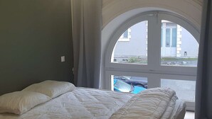 A bedroom with a bed, a window, and a view of the outside. - City center apartment - 10/12 guests (Cauterets)
