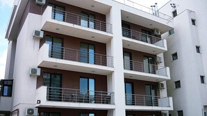 A multi-story building with balconies, air conditioning units, and a visible laundry area. - Apartamente Aquarium (Navodari)