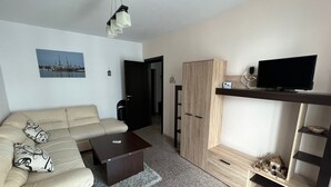 A modern living room with a sofa, coffee table, TV stand, and wardrobe. - Apartamente Aquarium (Navodari)