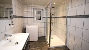 A modern bathroom with a white sink, a glass shower enclosure, and a toilet. - Spacious 6-person gîte in Kaysersberg (Kaysersberg)