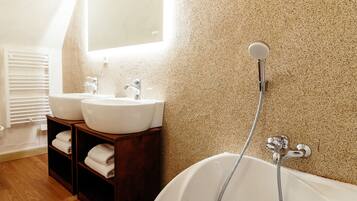 A bathroom with two sinks, a large bathtub, and a shower.