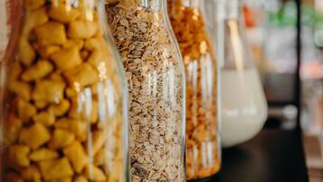 Glass jars filled with various grains and seeds on a shelf.