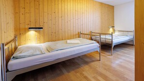 A room with two single beds, wooden walls, and a wooden floor. - Youth Hostel Engelberg (Engelberg)