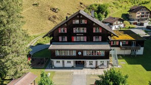 A large, two-story building with a prominent entrance and a staircase leading to the upper floor. - Youth Hostel Engelberg (Engelberg)