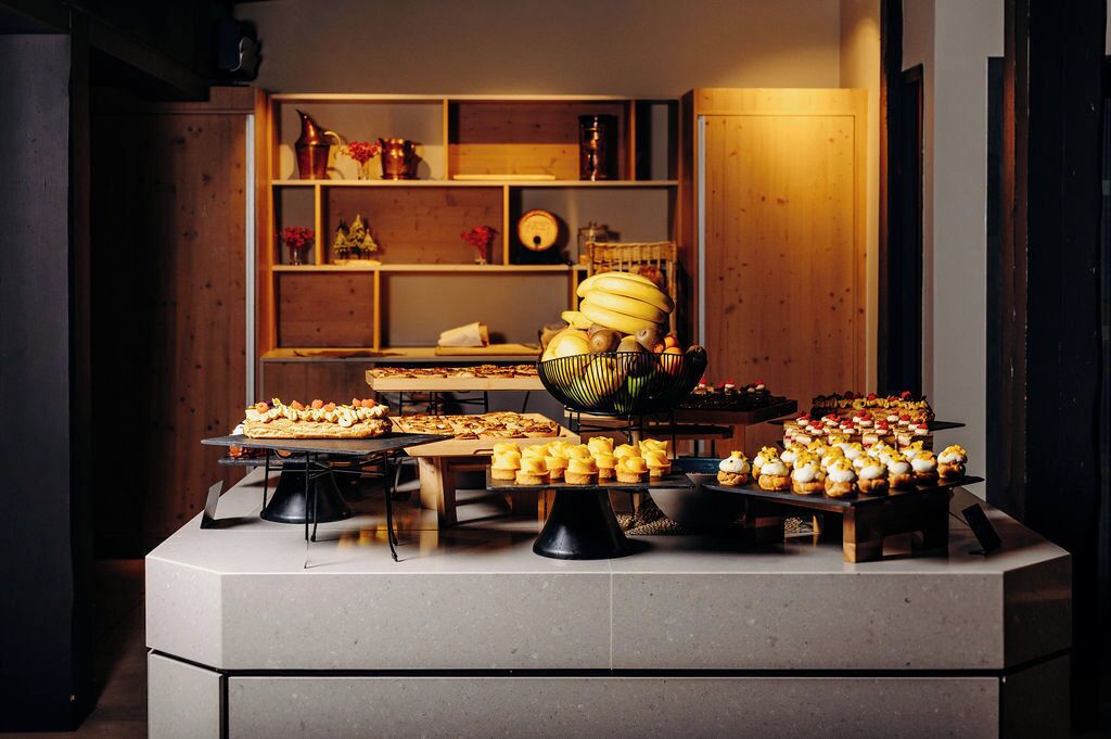 A buffet setup with various food items and a decorative shelf in the background.