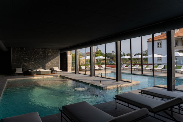 Piscine couverte, piscine extérieure, parasols de plage, chaises longues