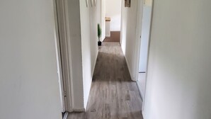 A narrow hallway with wooden flooring and white walls. - Stunning 2-bed Flat in Haverfordwest (Haverfordwest)