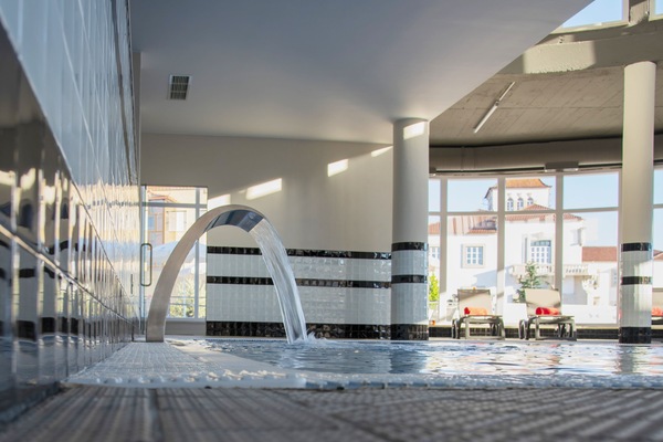 Una piscina cubierta, una piscina al aire libre de temporada, sombrillas