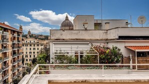 A rooftop terrace with a view of a cityscape, including a dome and buildings. - Casa Per Ferie Ravasco San Pietro (Rome)