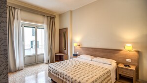 A hotel room with a bed, bedside lamps, a nightstand, and a window with curtains. - Casa Per Ferie Ravasco San Pietro (Rome)