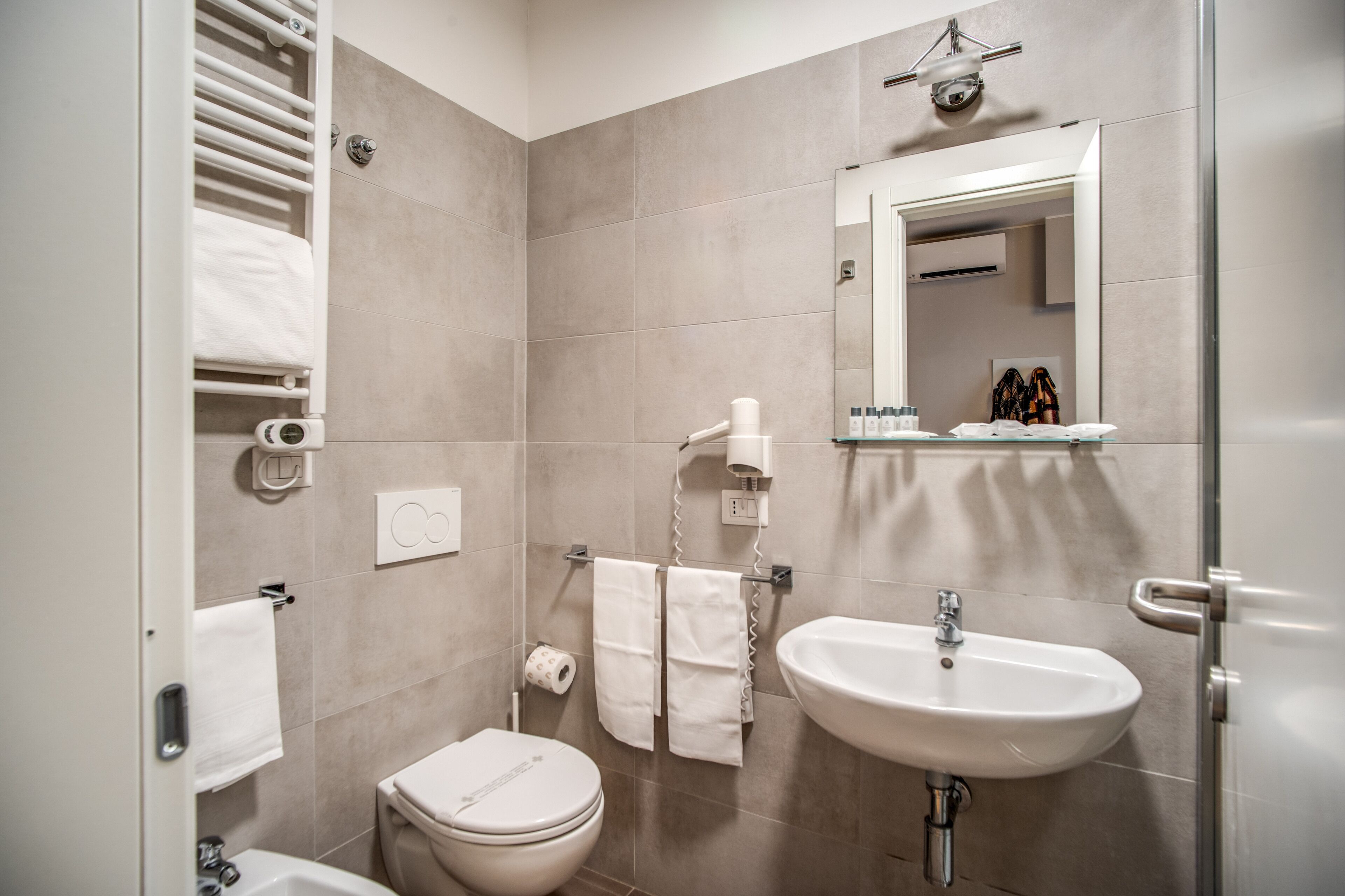A modern bathroom with a toilet, sink, and towel rack.