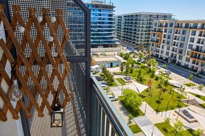 A modern building with a balcony, a view of a landscaped courtyard, and surrounding high-rise buildings. - Apartamente Papaya (Navodari)