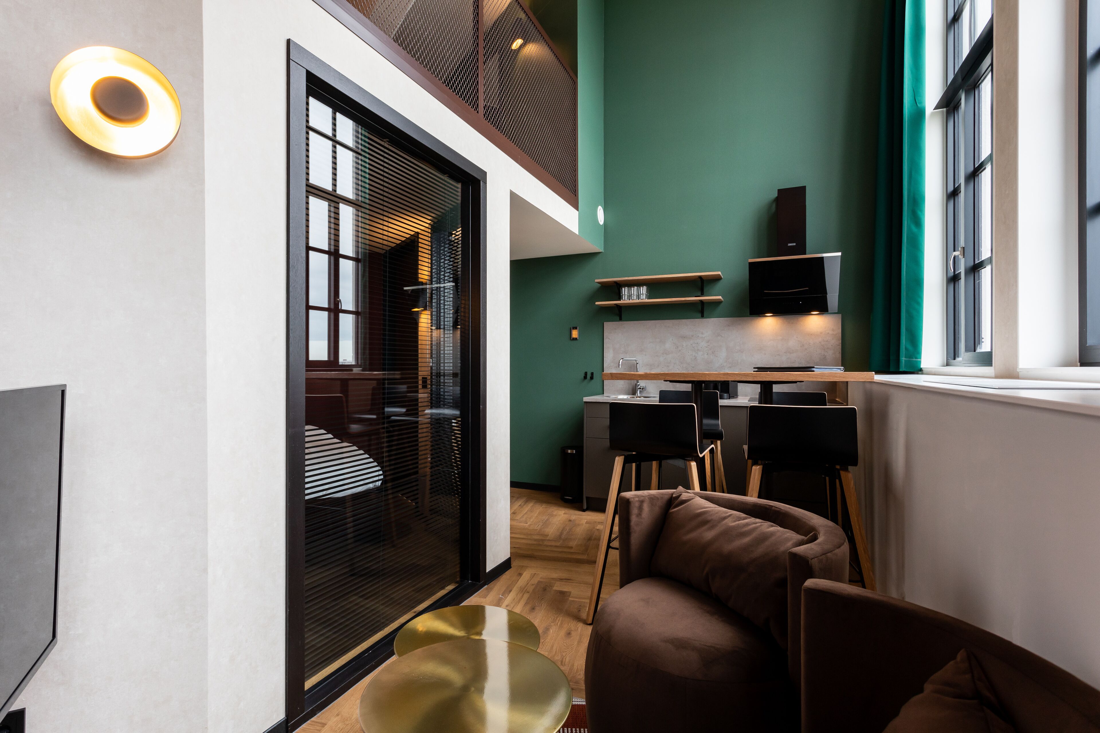 A modern living space with a sofa, a coffee table, a dining area with a table and chairs, and a kitchen area with a countertop and cabinets.
